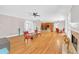 Open-concept living room with fireplace, hardwood floors, and seamless flow to kitchen at 328 Broadmoor Way, Mcdonough, GA 30253