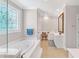 Elegant bathroom featuring a soaking tub, vanity, and tile flooring at 328 Broadmoor Way, Mcdonough, GA 30253