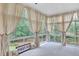 Bright sunroom featuring large windows offering scenic backyard views and natural light at 328 Broadmoor Way, Mcdonough, GA 30253