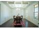 Formal dining room featuring wainscoting, coffered ceilings, and a large window for natural light at 4750 Sabino Bnd, Cumming, GA 30040