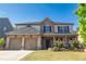 Charming brick and stone two-story home featuring a well-manicured lawn and a two-car garage at 4750 Sabino Bnd, Cumming, GA 30040