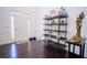 Inviting foyer with dark wood floors, decorative shelving and a white front door at 4750 Sabino Bnd, Cumming, GA 30040