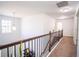 Bright hallway with wood railing, neutral carpet, and chandelier leading to the upper level at 4750 Sabino Bnd, Cumming, GA 30040