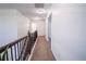 Upstairs hallway with neutral carpet, fresh paint, and a dark wood bannister at 4750 Sabino Bnd, Cumming, GA 30040