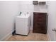 Functional laundry area with a washer, storage shelf, and dark wood drawers at 4750 Sabino Bnd, Cumming, GA 30040