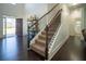 Elegant carpeted staircase featuring a dark wood railing and access to the upper level at 4750 Sabino Bnd, Cumming, GA 30040