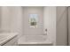 Bright bathroom featuring a tub, window, and countertop with a sink at 1316 Village Brook Drive, Dacula, GA 30019