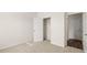 Bright bedroom with neutral carpet and an open closet; white walls and white door at 1316 Village Brook Drive, Dacula, GA 30019
