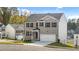 Charming two-story home with a light brick exterior, a two-car garage, and manicured lawn at 1316 Village Brook Drive, Dacula, GA 30019