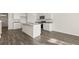 Bright, modern kitchen with stainless steel appliances, granite counters, island and grey wood flooring at 1316 Village Brook Drive, Dacula, GA 30019