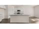 Open-concept kitchen with granite countertops, stainless steel appliances, white cabinets and a central island at 1316 Village Brook Drive, Dacula, GA 30019