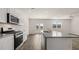 Modern kitchen with granite countertops, stainless steel appliances, and an island overlooking the dining area at 1316 Village Brook Drive, Dacula, GA 30019