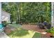 Serene backyard featuring a mix of artificial turf, pine straw and mature trees, creating a natural setting at 2000 Suttles Sw Dr, Atlanta, GA 30331