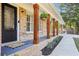 Inviting front porch with brick columns, hanging plants, and a stylish entrance, creating a welcoming exterior at 4125 Hickory Dr, Powder Springs, GA 30127