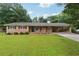 Charming brick ranch-style home with a well-manicured lawn and covered carport, creating curb appeal at 4125 Hickory Dr, Powder Springs, GA 30127