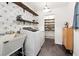 Bright laundry room has patterned wallpaper, floating shelves, and modern appliances at 4125 Hickory Dr, Powder Springs, GA 30127