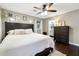 Comfortable main bedroom features hardwood floors, a ceiling fan, and an ensuite bathroom at 4125 Hickory Dr, Powder Springs, GA 30127