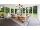 Relax in screened-in porch with comfortable seating, ceiling fan, and great views of landscaped backyard at 4125 Hickory Dr, Powder Springs, GA 30127