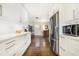 Galley kitchen featuring white cabinets, stainless steel refrigerator and microwave, and hardwood floors at 4128 Morgan Rd, Tucker, GA 30084
