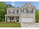 Two-story home features gray siding, brick accents, and a two-car garage at 4827 Golden Finch Ln, Powder Springs, GA 30127