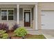 Inviting front entrance with a glass-paneled door, white columns, and landscaped greenery at 4827 Golden Finch Ln, Powder Springs, GA 30127