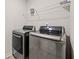 This laundry room features silver appliances, overhead shelving, and neutral walls for a clean, organized space at 4827 Golden Finch Ln, Powder Springs, GA 30127