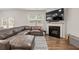 View of the living room with large gray sectional sofa, fireplace and flatscreen TV; natural light from windows at 4827 Golden Finch Ln, Powder Springs, GA 30127