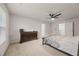 Well-lit main bedroom with large bed, dresser, ceiling fan, and carpeted floor at 4827 Golden Finch Ln, Powder Springs, GA 30127