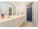 Bathroom featuring dual sinks and a doorway to the shower at 5215 Tealing Ne Dr, Roswell, GA 30075