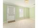 Bedroom featuring neutral carpet, pale green walls, a window, and access door to the exterior of the home at 5215 Tealing Ne Dr, Roswell, GA 30075