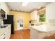 Bright kitchen featuring wooden floors, appliances, and a view of a laundry room at 5215 Tealing Ne Dr, Roswell, GA 30075