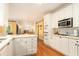 Modern kitchen with white cabinets, stainless steel appliances, and an open layout to dining area at 5215 Tealing Ne Dr, Roswell, GA 30075