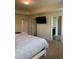 Bright bedroom with a flat screen television, neutral color palette, and view of the en suite bathroom at 11813 Lovejoy Crossing Blvd, Hampton, GA 30228