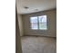 Bright bedroom with large window, neutral carpet, and a ceiling light fixture at 11813 Lovejoy Crossing Blvd, Hampton, GA 30228
