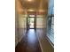 Hallway with dark wood flooring leading to a window and front door at 11813 Lovejoy Crossing Blvd, Hampton, GA 30228