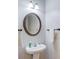 Powder room with pedestal sink, decorative mirror, and brushed bronze fixtures at 2725 Sedgeview Way, Buford, GA 30519