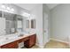Bathroom with dual sinks, wood cabinets, tile floor, and a separate tub and shower at 2725 Sedgeview Way, Buford, GA 30519