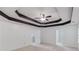 Large primary bedroom with decorative tray ceiling, ceiling fan, and access to attached bathroom at 2725 Sedgeview Way, Buford, GA 30519