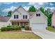Charming two-story home with a well-manicured lawn, black shutters, and an attached two car garage at 2725 Sedgeview Way, Buford, GA 30519