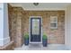 Inviting front door with decorative glass, flanked by potted plants and a brick facade at 2725 Sedgeview Way, Buford, GA 30519