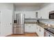 Close-up of kitchen featuring stainless steel refrigerator and white cabinets at 2725 Sedgeview Way, Buford, GA 30519