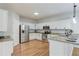 Bright kitchen with stainless steel appliances, white cabinetry, and tile backsplash at 2725 Sedgeview Way, Buford, GA 30519