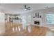 Open-concept living room features hardwood floors, fireplace, and a ceiling fan overlooking the kitchen at 2725 Sedgeview Way, Buford, GA 30519