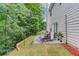 Backyard patio features a table, chairs, and trees with a downward sloping hill at 2725 Sedgeview Way, Buford, GA 30519