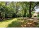 Backyard features a manicured lawn, trees, and a decorative rock border at 2790 Shiloh Way, Snellville, GA 30039