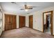 Carpeted bedroom featuring natural wood closets and trim, along with a ceiling fan with light at 2790 Shiloh Way, Snellville, GA 30039