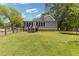 Back exterior of a gray two-story home with a well-manicured lawn and wood fence at 527 Main St, Suwanee, GA 30024