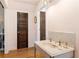 Elegant bathroom with marble sink, hardwood floors and dark wooden doors at 527 Main St, Suwanee, GA 30024