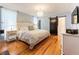 Bright bedroom with a large bed, barn door to bathroom, wood floors, and a mounted television at 527 Main St, Suwanee, GA 30024