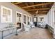 Relaxing covered patio featuring stone flooring, wood ceilings, and ample seating at 527 Main St, Suwanee, GA 30024